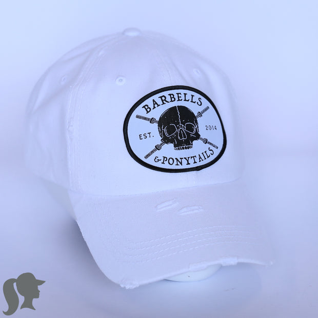 solid white ponytail hat with skulls and barbells text