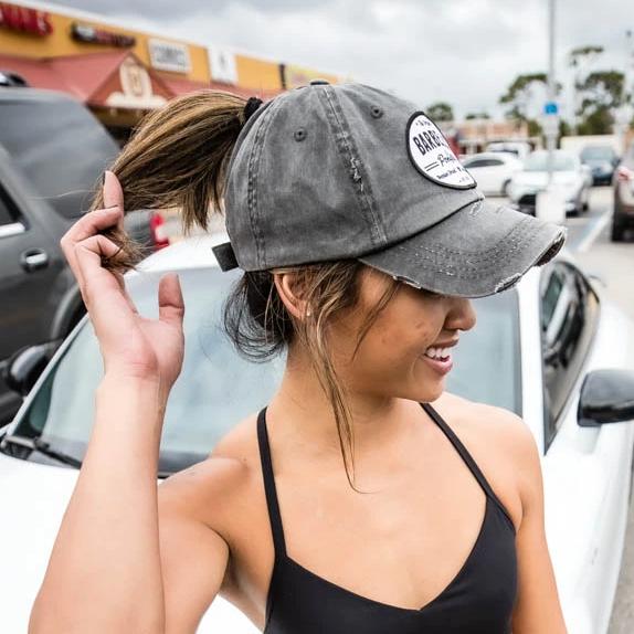 solid dark grey ponytail hat with barbells and ponytails text