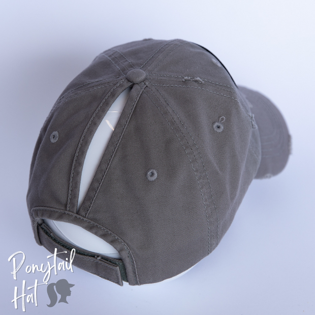 solid light grey ponytail hat with skulls and barbells text