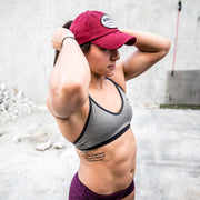 solid maroon ponytail hat with barbells and ponytails text