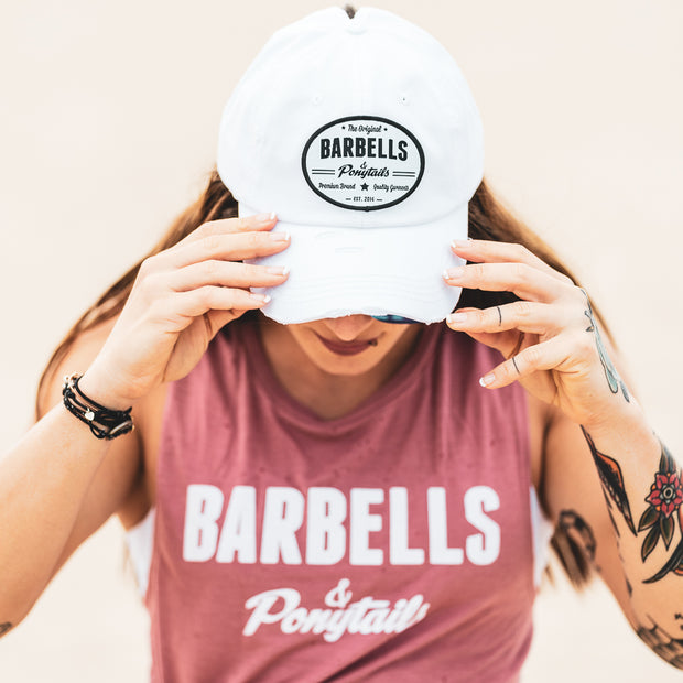 solid white ponytail hat with barbells and ponytails text