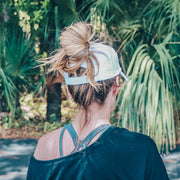 solid white ponytail hat with barbells and ponytails text