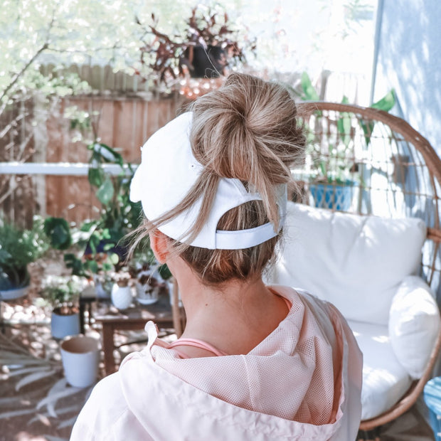 solid white ponytail hat with barbells and ponytails text